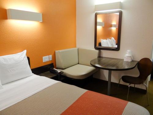 a hotel room with a bed and a table and a mirror at Motel 6-Erie, PA in Erie
