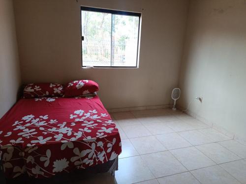 a small bedroom with a bed and a window at Casa Nova aeroporto in Luque