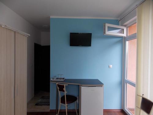 プリモルスコにあるGuest House Nedelcheviの青い壁の客室で、テーブルと椅子が備わります。