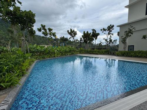 a large blue swimming pool in front of a house at Simple Stay Aston Acacia Bukit Mertajam in Bukit Mertajam