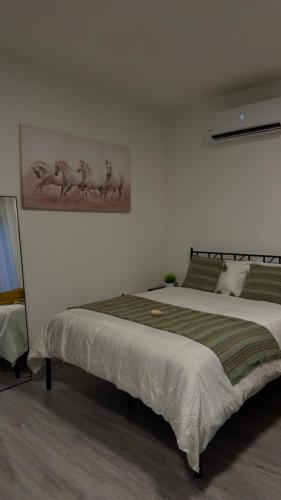 a bedroom with two beds and a painting on the wall at Ever Blue Suites Inspired by Nature in Ma‘yan Barukh