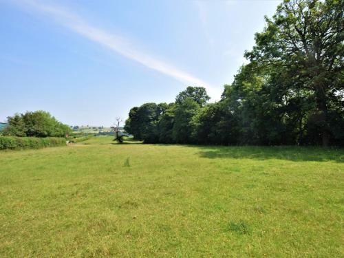 a field of grass with trees in the background at 1 Bed in Presteigne 78351 in Kinsham