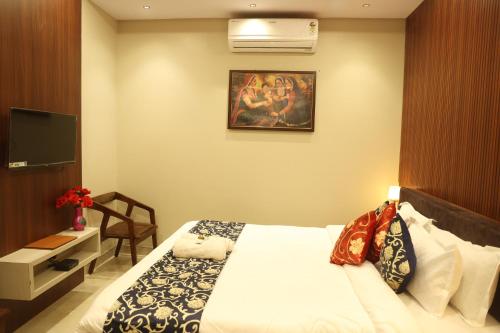 a hotel room with a bed and a flat screen tv at Shiv Hari Mahal in Jodhpur