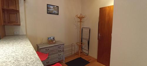a bedroom with a dresser and a bed and a door at Maison en Pierre et Colombage à Entraygues in Entraygues-sur-Truyère