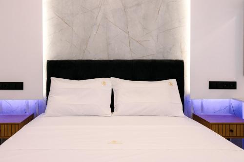 a bed with two white pillows and a headboard at MHVolos Suites in Volos