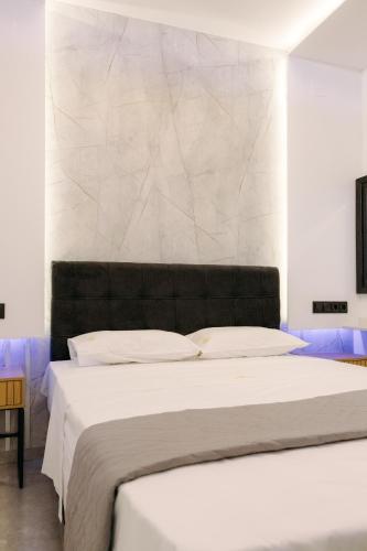 a bedroom with a large bed with white sheets at Nuance Residences - Momento in Volos