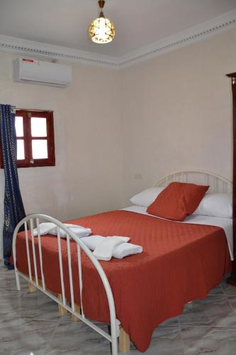 a bedroom with a bed with red and white sheets at La Belle Vue Guest House in Aït Ben Haddou