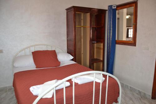 a bedroom with a bed with red and white pillows at La Belle Vue Guest House in Aït Ben Haddou