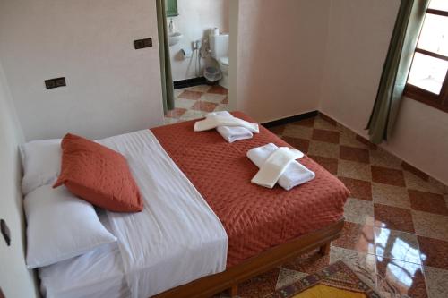 a bedroom with a bed with towels on it at La Belle Vue Guest House in Aït Ben Haddou