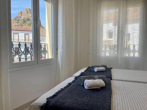 una camera da letto con due asciugamani su un letto con finestra di Mirador Castillo Belmez a Bélmez