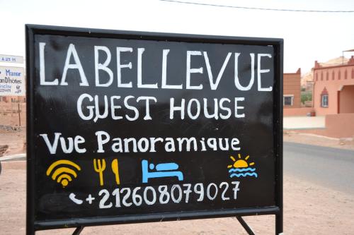 a sign for a guest house on the side of the road at La Belle Vue Guest House in Aït Ben Haddou