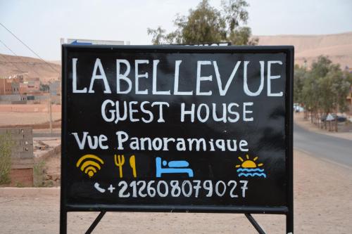 a sign for a guest house on the side of a road at La Belle Vue Guest House in Aït Ben Haddou