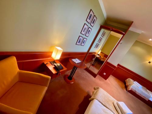 a living room with a couch and a mirror at Hotel Wawrzyniak in Zduny