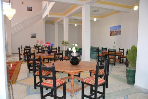 a dining room with wooden tables and chairs at La Belle Vue Guest House in Aït Ben Haddou