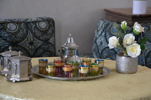 a tray of candles on a table with a vase of flowers at La Belle Vue Guest House in Aït Ben Haddou