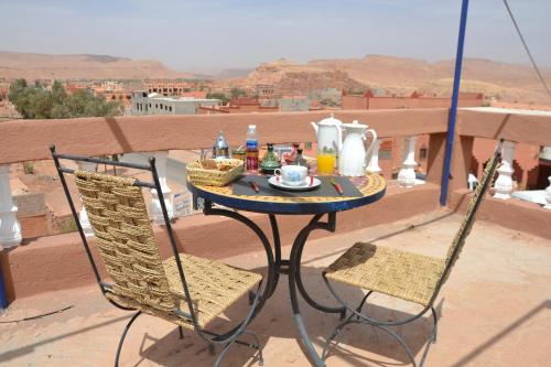 a table and chairs sitting on top of a balcony at La Belle Vue Guest House in Aït Ben Haddou