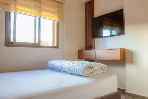 a bedroom with a bed and a flat screen tv at 2 bedrooms abouab gueliz in Marrakech