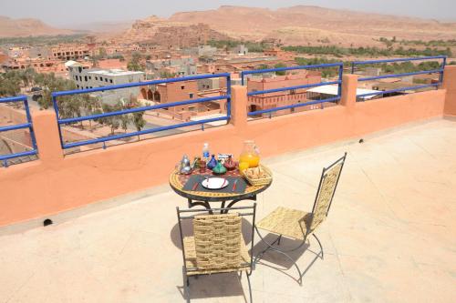 a table and chairs on a balcony with a view at La Belle Vue Guest House in Aït Ben Haddou