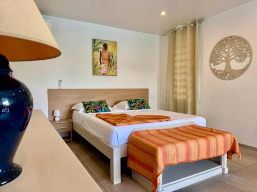 a bedroom with a bed and a table with a lamp at Villa TULIA in Sainte-Luce