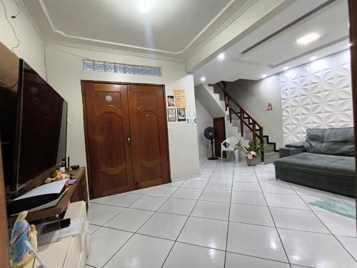 a living room with a couch and a television at Casa cop 30 in Belém