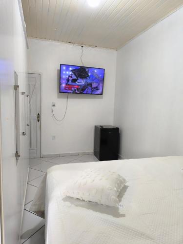 a bedroom with a bed and a tv on the wall at Casa cop 30 in Belém