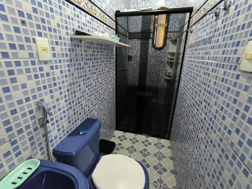 a bathroom with a toilet and a blue tiled wall at Casa cop 30 in Belém