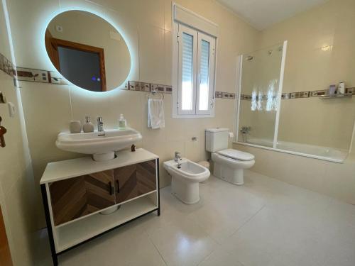 un bagno con lavandino, WC e specchio di Mirador Castillo Belmez a Bélmez