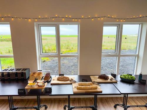 a table with some food on it with windows at Drangshlid Inn in Skogar