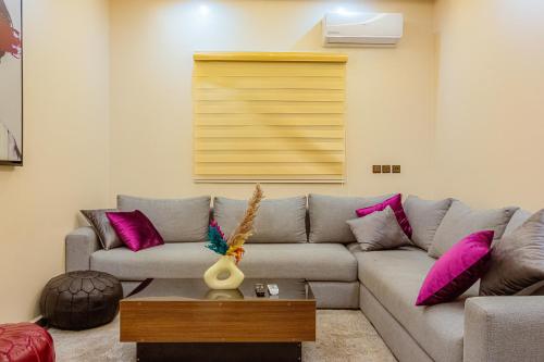 a living room with a gray couch and pink pillows at 2 bedrooms abouab gueliz in Marrakech