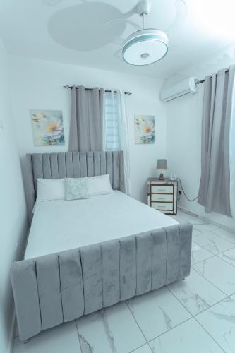 a bedroom with a large bed in a white room at Ventura Living in Nagua