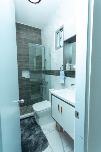 a bathroom with a toilet and a sink and a shower at Ventura Living in Nagua