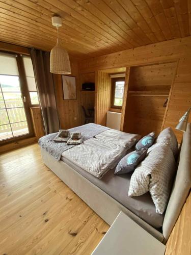 a bedroom with a bed in a wooden cabin at Agroturystyka Siedlisko in Lubowidz