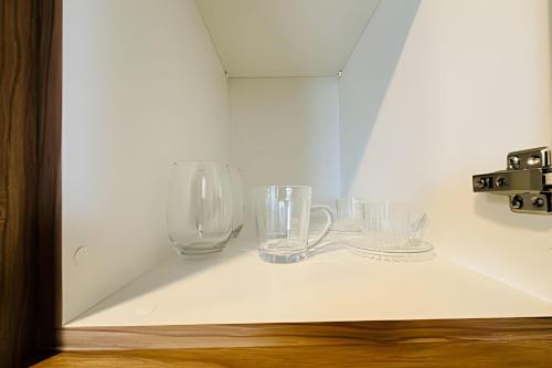a group of glasses sitting on a shelf at Loft 108 - Conforto e praticidade no Santa Mônica. in Uberlândia