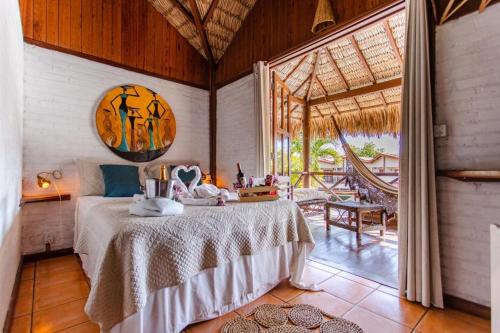 a bedroom with a bed and a large window at Pousada Maxitalia in Jericoacoara