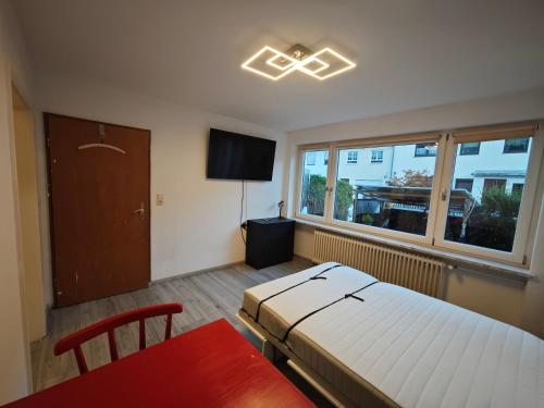 a bedroom with a bed and a table and a window at Einzimmerappartment München Solln in Munich