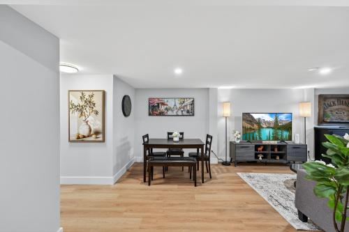 a living room with a table and a tv at Bright and Modern 2BR Suite with Rustic Bar in Kingston