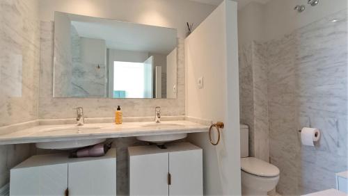 ein Badezimmer mit zwei Waschbecken und einer Toilette und einem Spiegel in der Unterkunft Casita Luxury- Grecia 3- Precioso apartamento en Hacienda del Alamo in Los Guerreros
