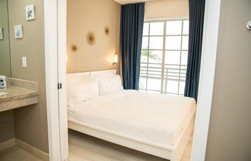 een kleine slaapkamer met een bed en een raam bij Spacious Studio Rooftop Pool & Bar with Ocean View in Miami Beach