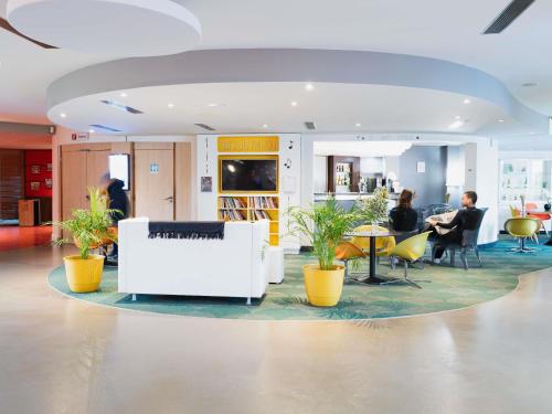 a lobby with people sitting at tables and chairs at ibis Styles Lyon Sud Vienne in Chasse-sur-Rhône