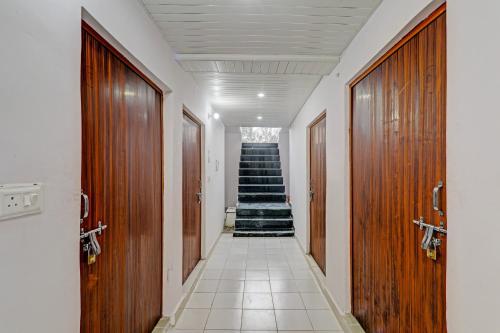 a hallway with wooden doors and stairs in a building at Hotel O The Blue Heart in Itaunja