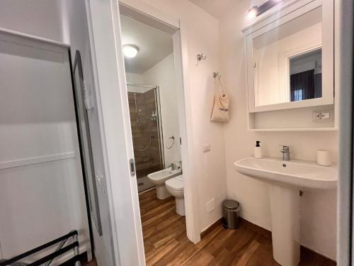 a white bathroom with a sink and a toilet at La Ca' di sogn in Pavia