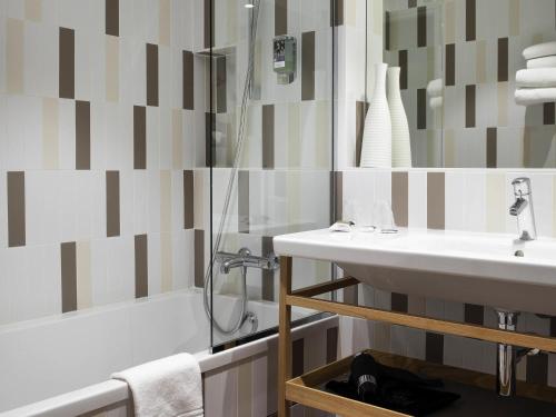 a bathroom with a sink and a shower and a tub at Mercure Lyon Charbonnières in Charbonnières-les-Bains