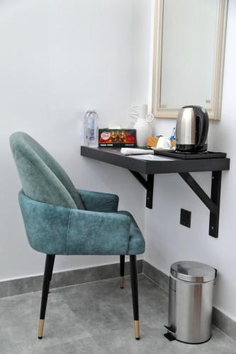 a green chair sitting in front of a desk at Rome Transit Hotel in Negombo