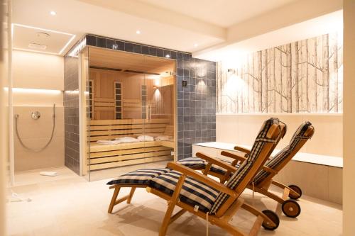 a bathroom with three wooden chairs and a table at Hummerklippen a in Süderende