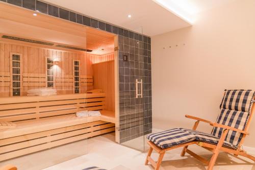 a bathroom with a sauna with a wooden chair at Hummerklippen b in Süderende