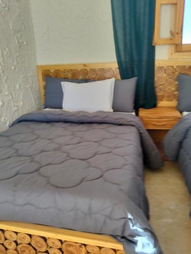 a bedroom with a large bed with a wooden frame at sabrina camp in Siwa