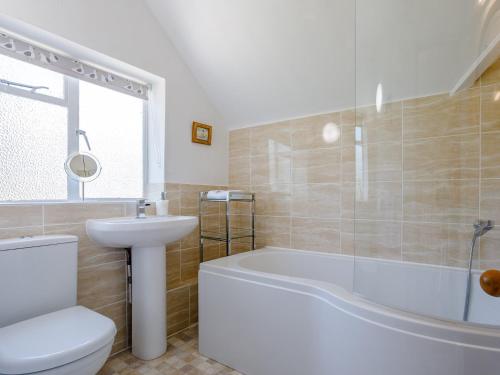 Un baño con bañera, inodoro y lavabo. en 3 Bed in Dawlish 72972, en Dawlish