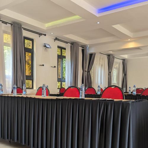 a meeting room with red chairs and a table in the middle at East Horizon Valley Nest in Eldoret