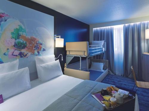 a hotel room with a bed with a tray of food on it at Mercure Toulouse Centre Saint-Georges in Toulouse