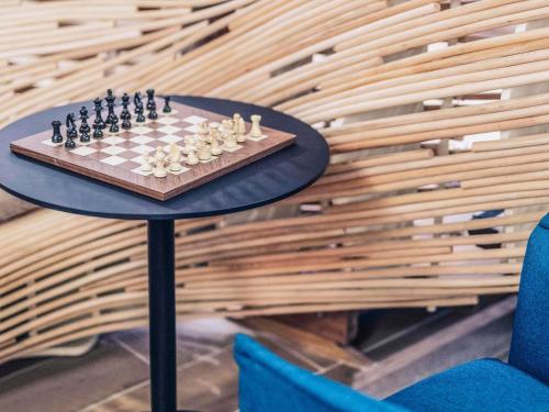 a chess board on a table with two chairs at Mercure Toulouse Centre Saint-Georges in Toulouse